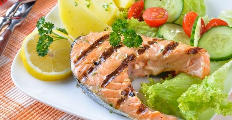 Grilled salmon steak with potatoes and salad
