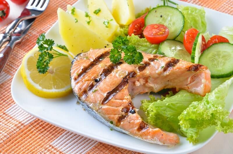 Grilled salmon steak with potatoes and salad