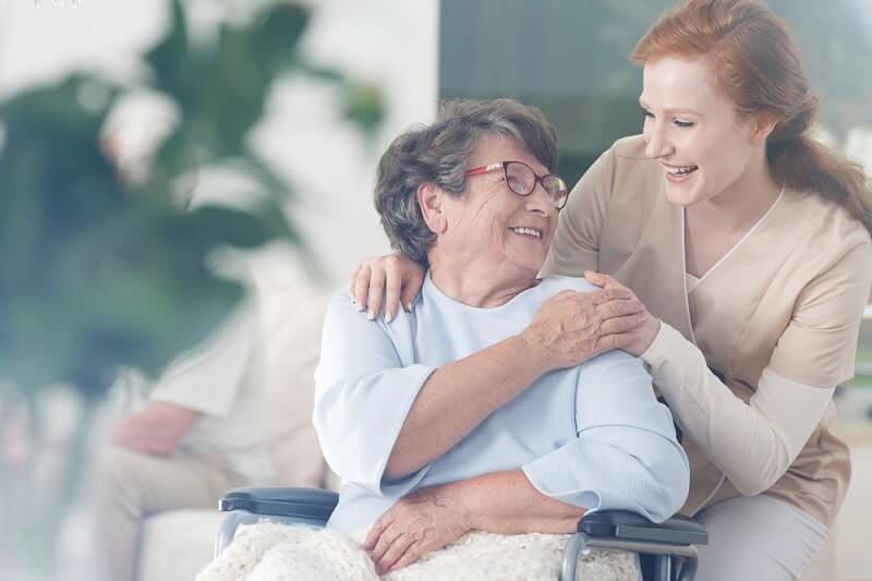 Happy parkinsons patient is holding caregiver for a hand while spending time together