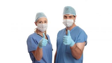 Two surgeons give the thumbs up eg: success, approval, quality