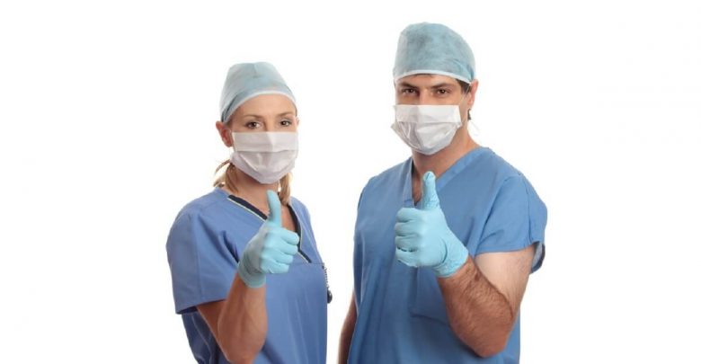 Two surgeons give the thumbs up eg: success, approval, quality