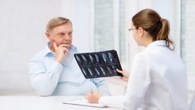 female doctor with old man looking at x-ray